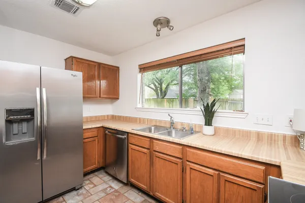 a kitchen with stainless steel appliances granite countertop a sink refrigerator and window