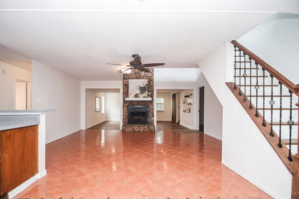 a view of a livingroom with wooden floor and staircase