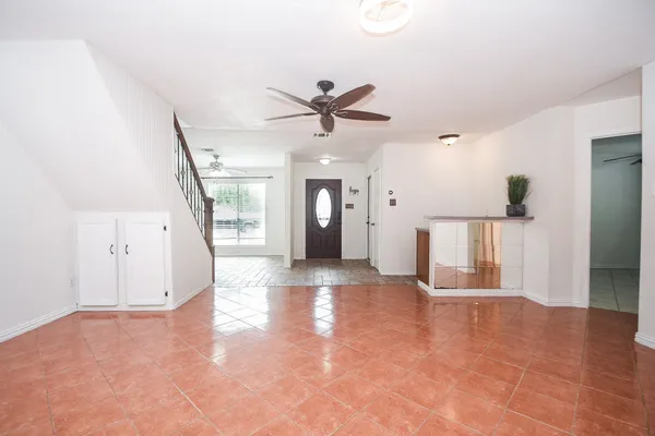 a view of a big room with wooden floor and a ceiling fan