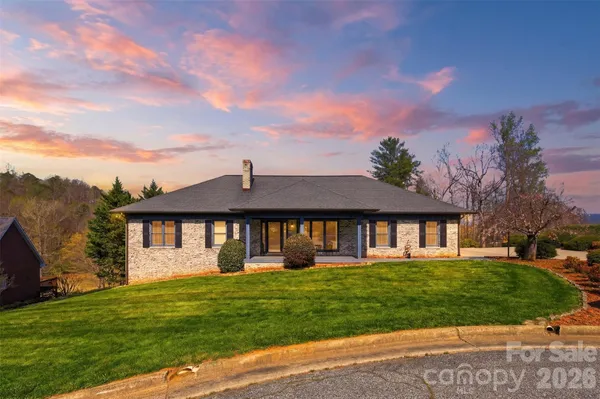 a front view of a house with a garden and lake view