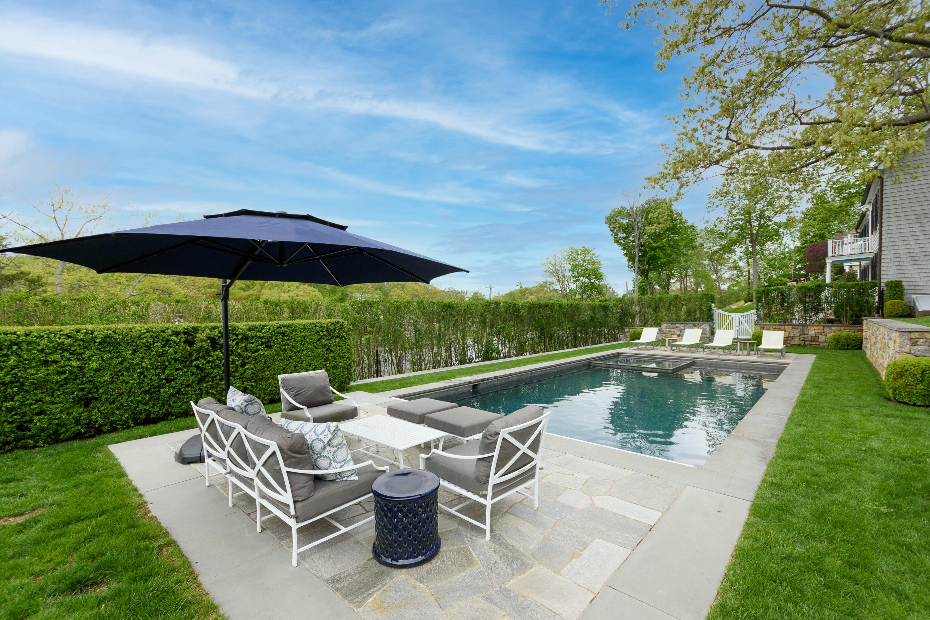 118 Goodwives River Road Darien, CT 06820 - Photo 48 of 68 a view of a patio with chairs under an umbrella