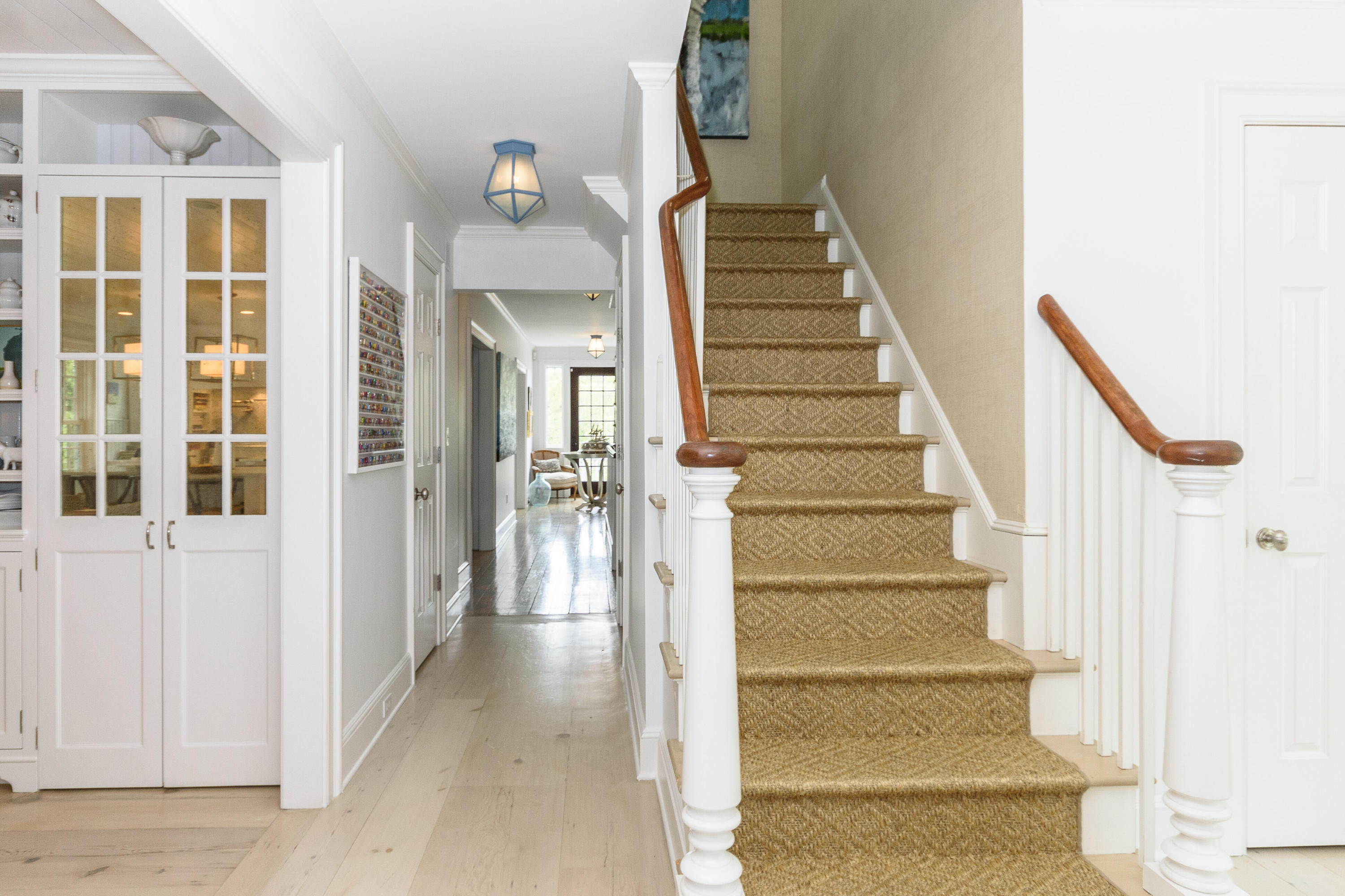 118 Goodwives River Road Darien, CT 06820 - Photo 9 of 68 a view of staircase with lots of frames on wall and a potted plant