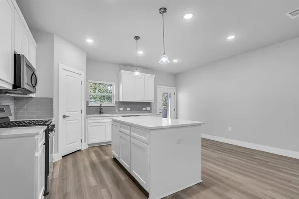 a kitchen with stainless steel appliances granite countertop a sink a stove and a refrigerator