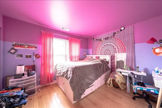 a bedroom with a bed and wooden floor