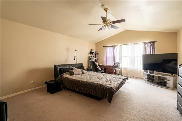 a bedroom with a bed and a flat tv screen on dresser