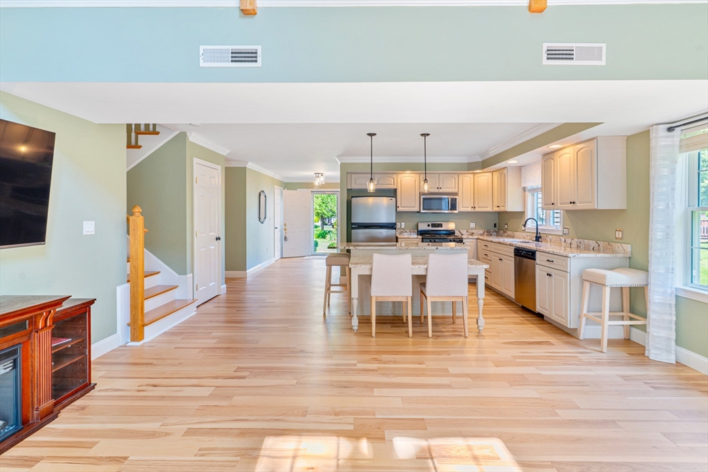53 Baldwin Road, Unit 1201 Billerica, MA 01821 - Photo 11 of 36 a dining hall with stainless steel appliances kitchen island granite countertop a table chairs and a large window