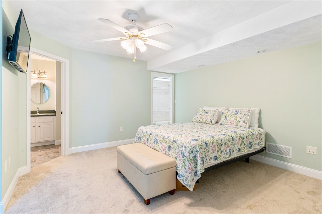 53 Baldwin Road, Unit 1201 Billerica, MA 01821 - Photo 15 of 36 a bedroom with a large bed a flat tv screen and a chandelier