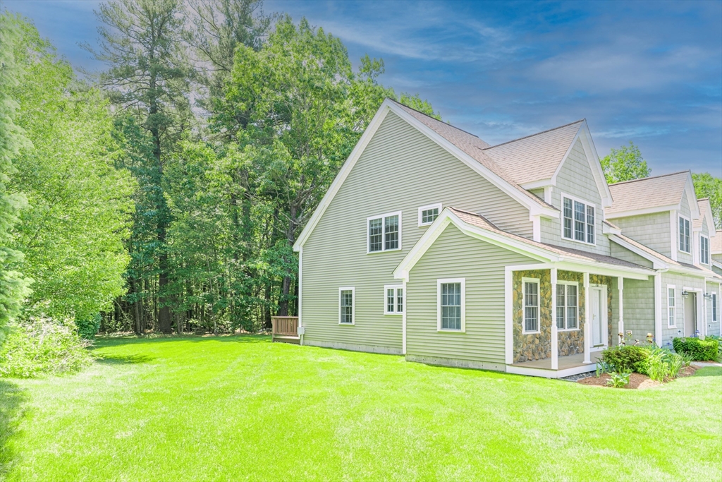 53 Baldwin Road, Unit 1201 Billerica, MA 01821 - Photo 3 of 36 a view of a yard in front of a house with plants and large tree