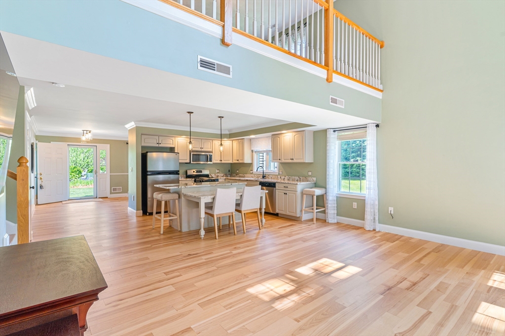 53 Baldwin Road, Unit 1201 Billerica, MA 01821 - Photo 10 of 36 a dining hall with stainless steel appliances a dining table chairs and couches with wooden floor