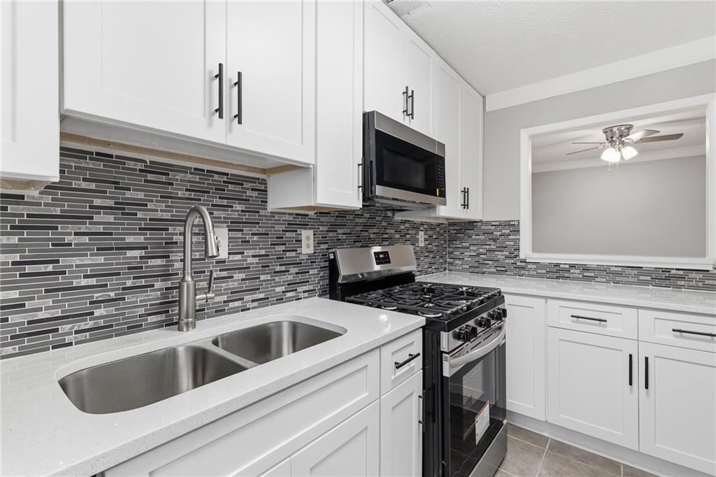 601 Wynnes Ridge Circle Southeast Marietta, GA 30067 - Photo 12 of 28 a kitchen with white cabinets sink and stainless steel appliances