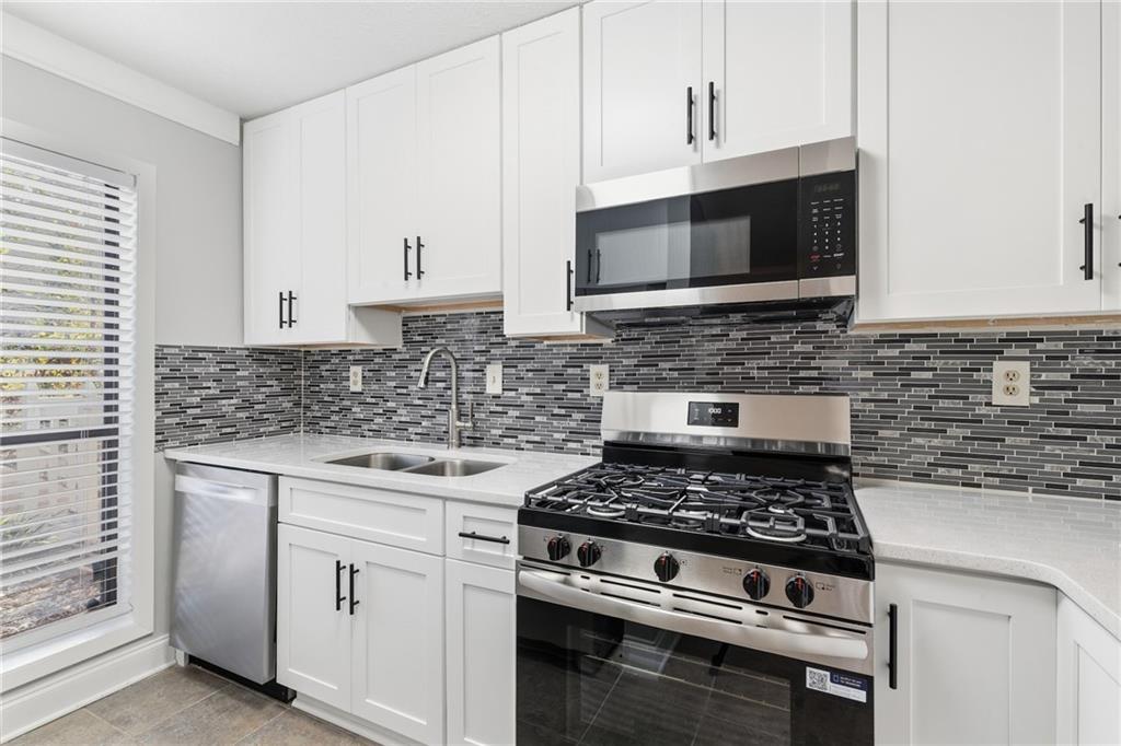 601 Wynnes Ridge Circle Southeast Marietta, GA 30067 - Photo 13 of 28 a kitchen with stainless steel appliances a stove and a microwave