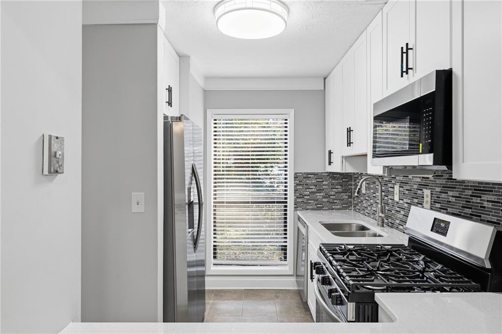 601 Wynnes Ridge Circle Southeast Marietta, GA 30067 - Photo 14 of 28 a kitchen with stainless steel appliances a stove a sink and a microwave
