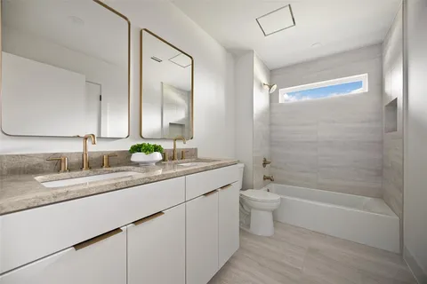 a bathroom with a double vanity sink toilet and shower