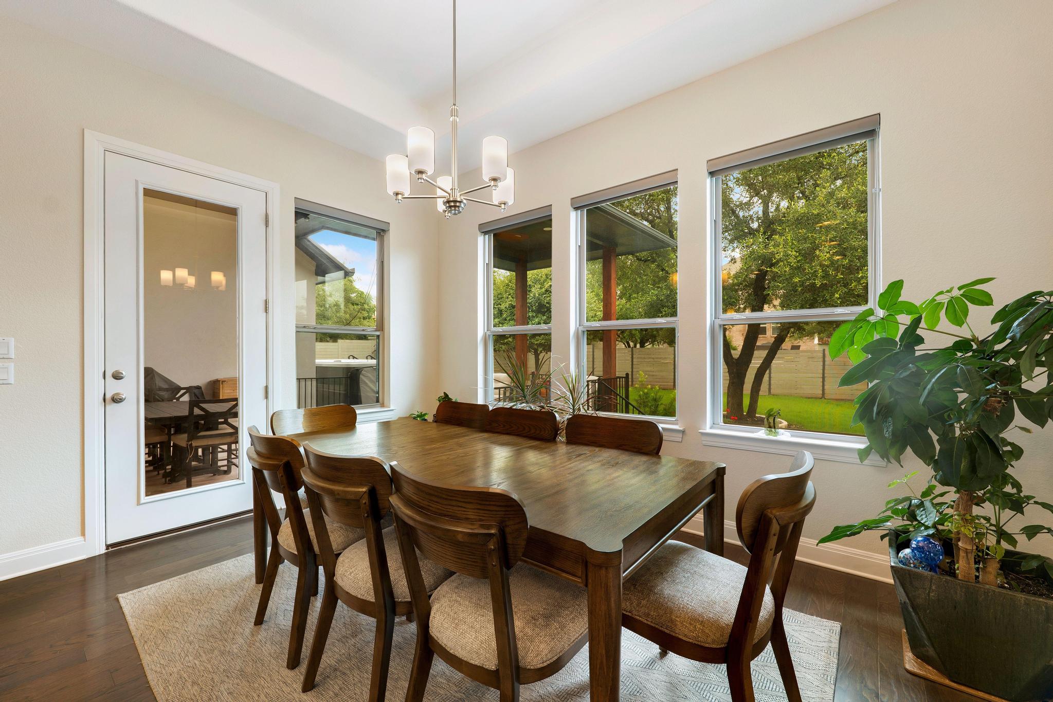 1009 Legacy Crossing Georgetown, TX 78628 - Photo 28 of 40 Natural light floods this inviting dining space, highlighting dark wood floors and a direct outdoor connection.