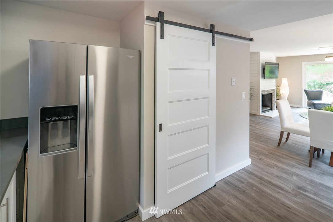 13839-13841 Southeast Allen Rd. Bellevue, WA 98006 - Photo 11 of 25 a view of a refrigerator in kitchen and an empty room with wooden floor windows