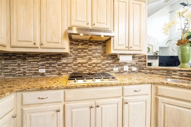 a kitchen with granite countertop white cabinets and a window