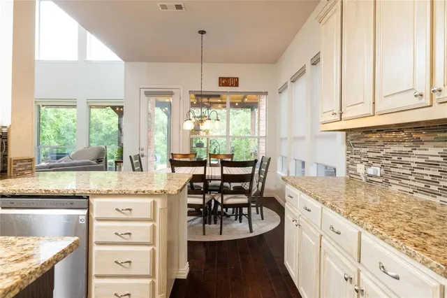 a kitchen with granite countertop white cabinets and window