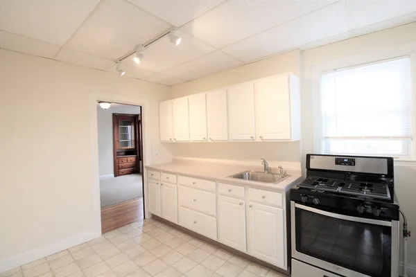 a kitchen with white cabinets and refrigerator