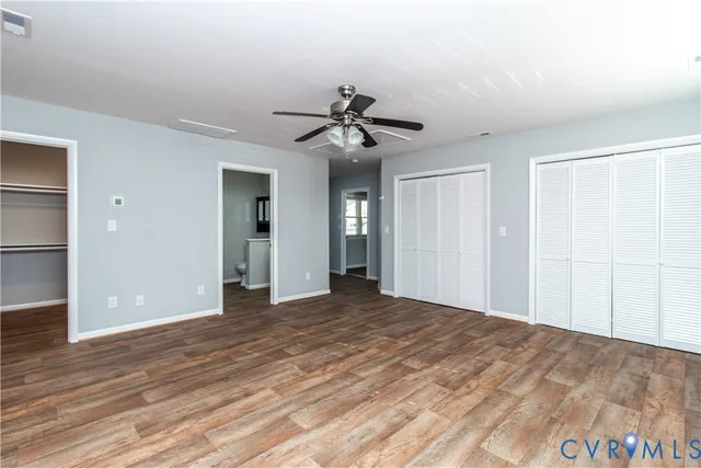 a view of empty room with wooden floor and ceiling fan