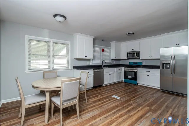 a kitchen with a table chairs sink and cabinets