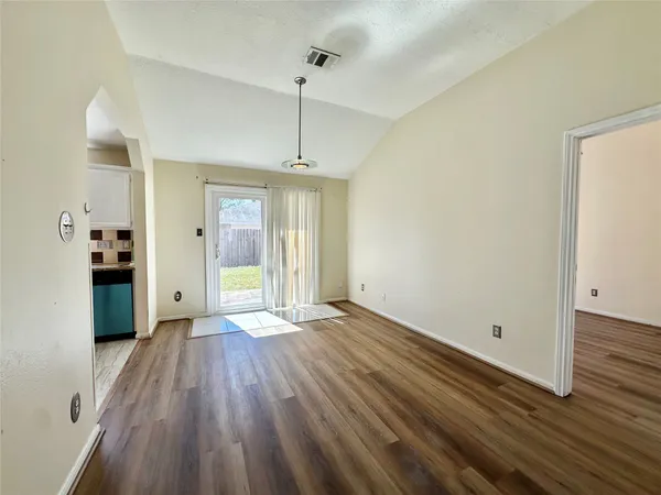 a view of empty room with wooden floor and window