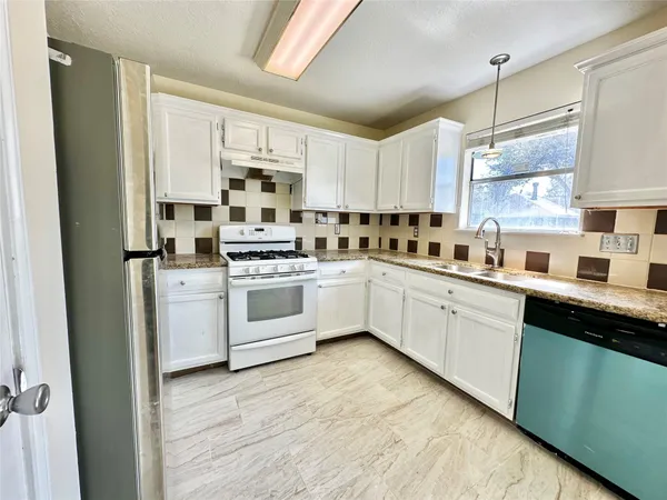 a kitchen with white cabinets sink and white appliances