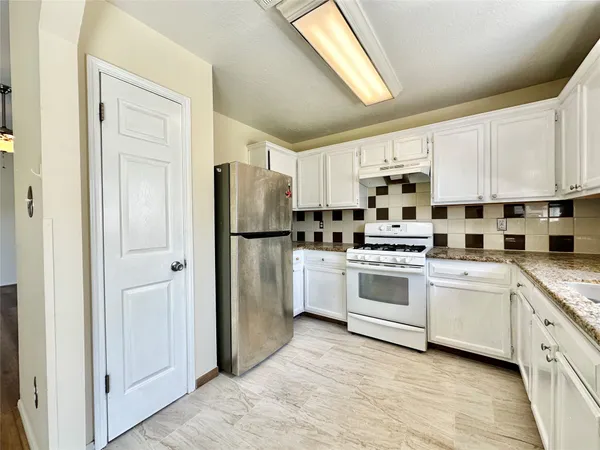 a kitchen with stainless steel appliances a refrigerator sink and cabinets
