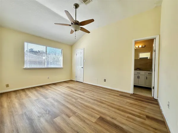 a view of a room with wooden floor and a ceiling fan