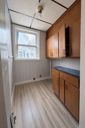 a view of an empty room with wooden floor and windows