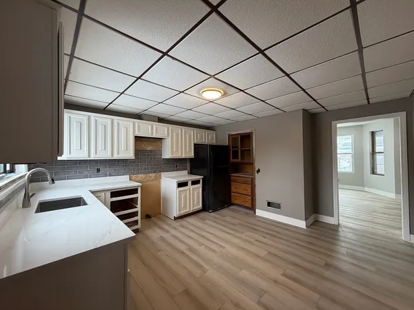 a kitchen with stainless steel appliances kitchen island granite countertop a sink cabinets and wooden floor