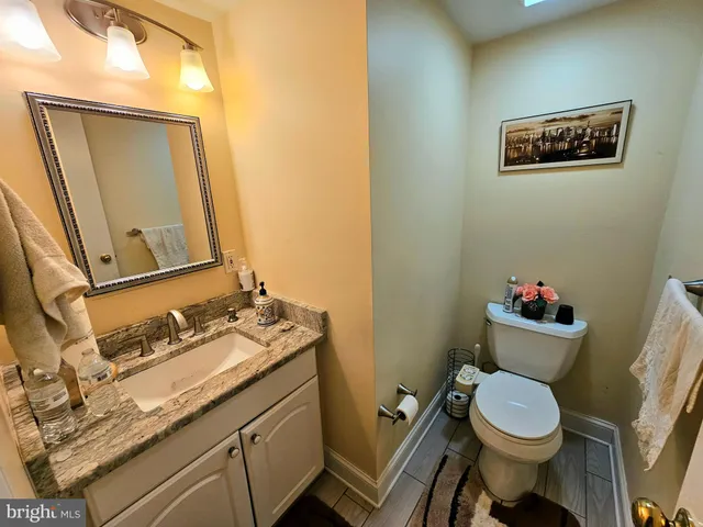 a bathroom with a toilet sink vanity and mirror