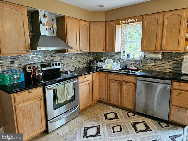 a kitchen with granite countertop a sink stove and cabinets