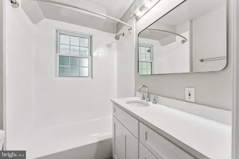 a bathroom with a sink a vanity and a bathtub