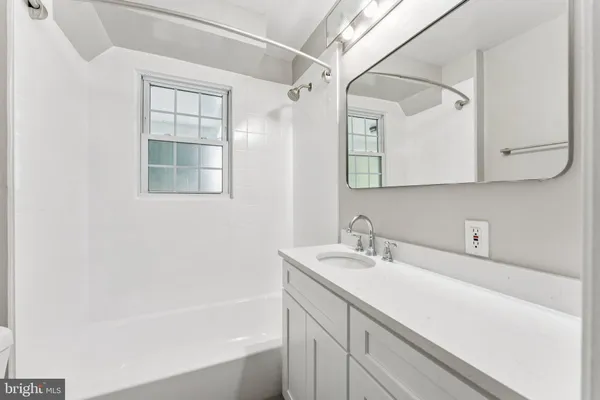 a bathroom with a sink a vanity and a bathtub