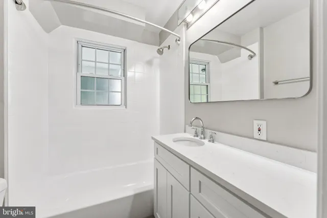 a bathroom with a sink a vanity and a bathtub