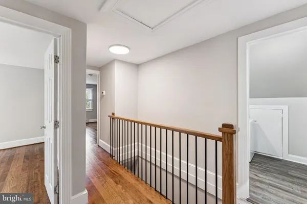 a view of a hallway with wooden floor and staircase