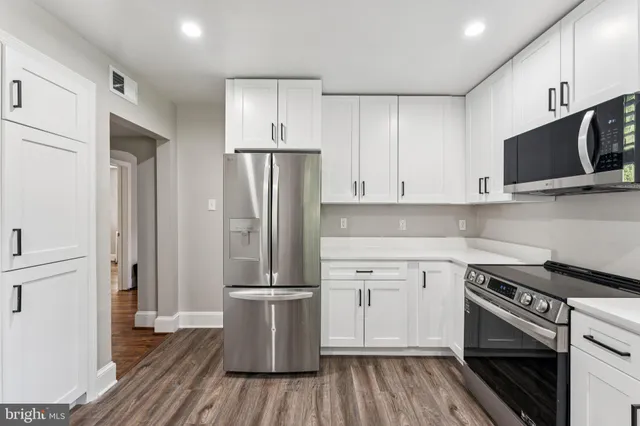 a kitchen with a refrigerator and a stove top oven