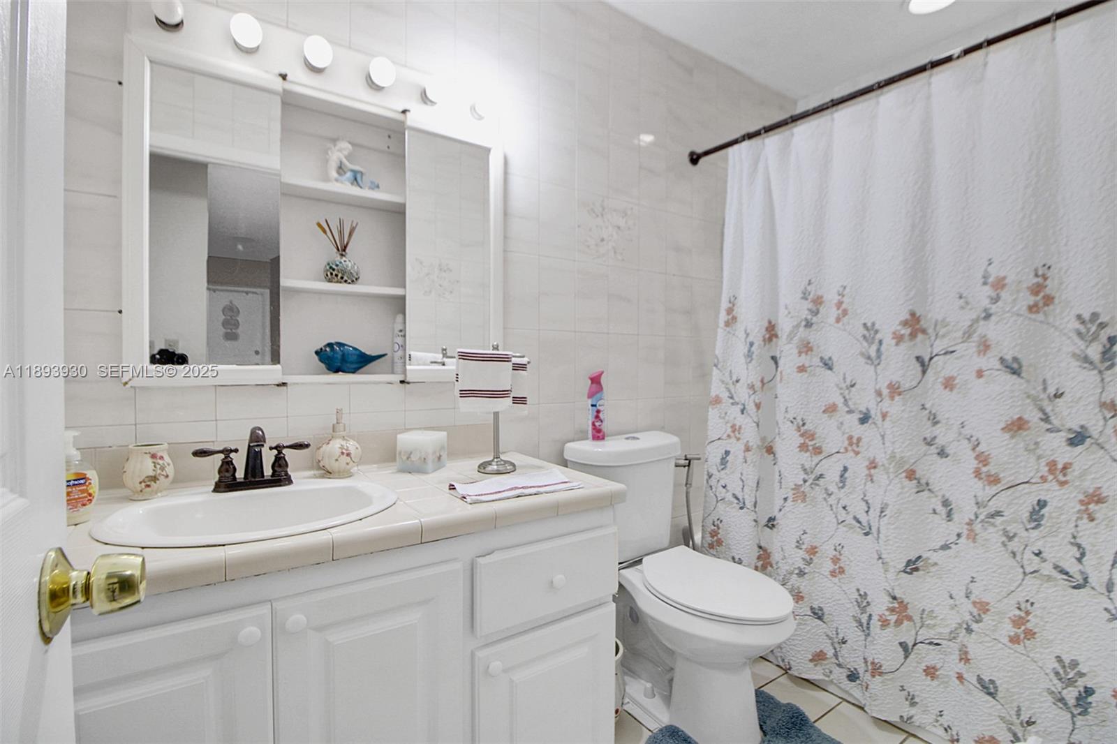 13246 Southwest 9th Terrace Miami, FL 33184 - Photo 12 of 34 a bathroom with a sink a toilet and a mirror