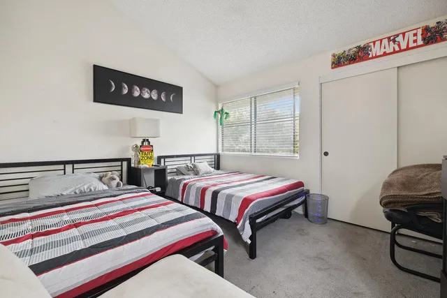 a bedroom with two beds and a desk