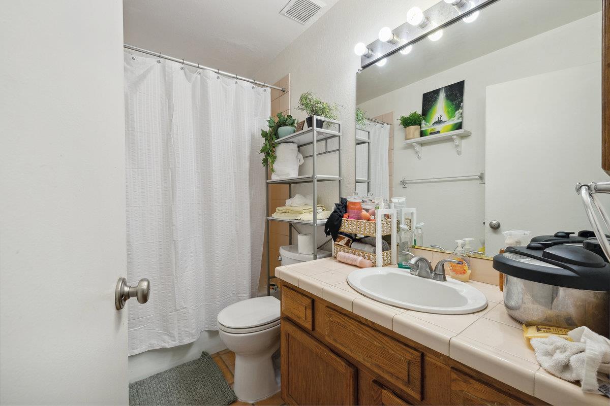 415 West Gutierrez Street, Unit 11 Santa Barbara, CA 93101 - Photo 9 of 16 a bathroom with a granite countertop sink toilet and a mirror