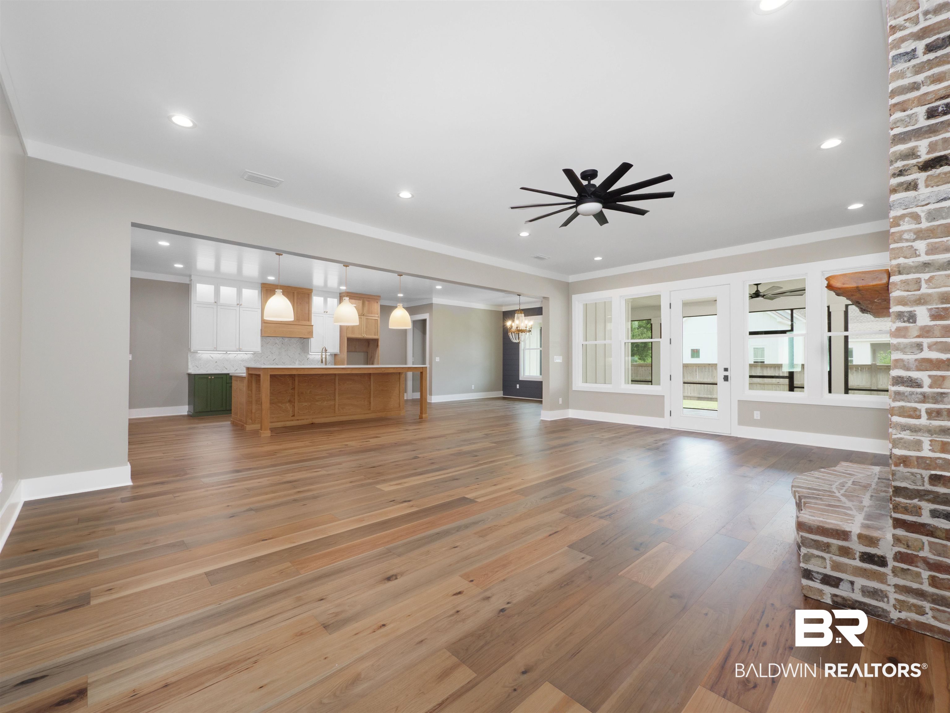 10970 Turin Avenue Fairhope, AL 36532 - Photo 6 of 61 Unfurnished living room featuring crown molding, dark wood-type flooring, a chandelier, a ceiling fan, and recessed lighting
