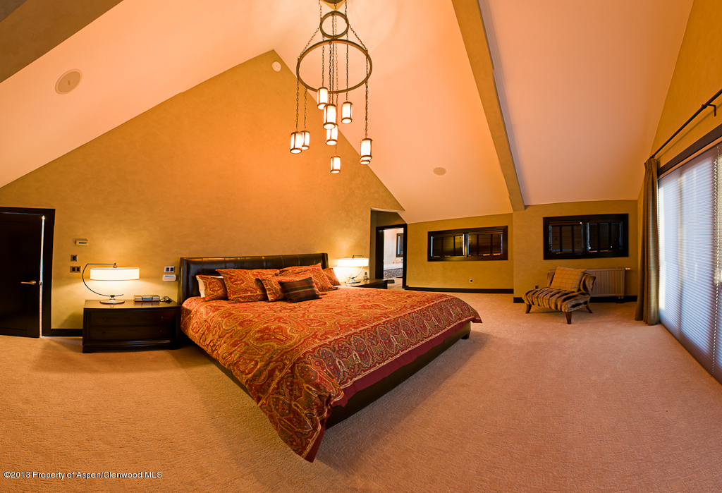 180 Riverside Drive Basalt, CO 81621 - Photo 8 of 14 a spacious bedroom with a bed a flat screen tv and dresser