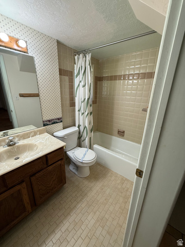 328 Heather Ridge Circle Sandy, UT 84070 - Photo 29 of 32 Bathroom featuring a shower-tub combination with tiled surround, a wood-finish vanity with an integrated sink, a toilet, and patterned wallpaper