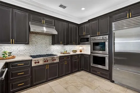 a kitchen with stainless steel appliances granite countertop wooden cabinets and a stove top oven