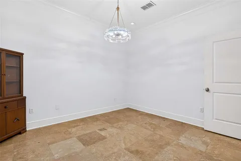 a view of an empty room and a chandelier fan