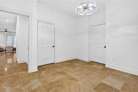 an empty room with an entryway and fan
