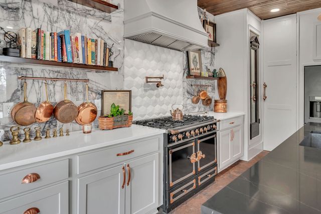 a kitchen with stainless steel appliances granite countertop a stove and a wooden floor