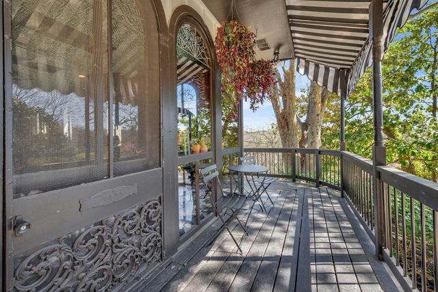 a view of a patio with wooden floor barbeque oven and trees