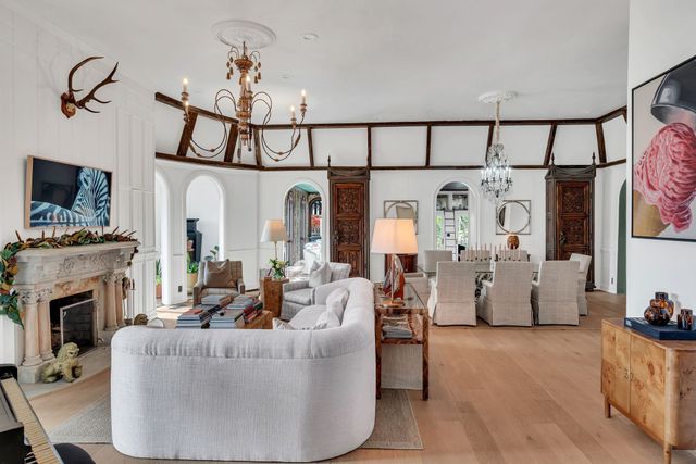 a living room with furniture a fireplace and a chandelier