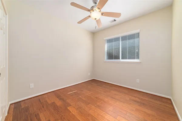 an empty room with a window and a fan